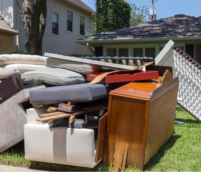 water damaged household furniture sitting outside on front lawn